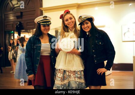 Three college students pose for a picture, two girls on the ends are dressed as sailors with sailor hats and the girl in the middle is dressed as Alice in Wonderland and is holding a clock, 2015. Courtesy Eric Chen. Stock Photo