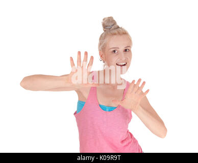 A lovely young blond Caucasian woman in a pink t-shirt holding her hands up to push away something, isolated for white background Stock Photo