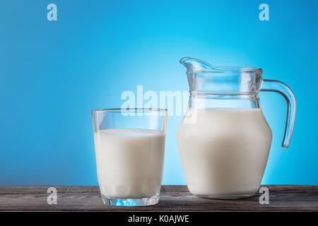 Milk in a glass and jug on a wooden table Stock Photo