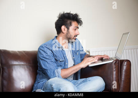 Asian man using Laptop at home in the lounge. Stock Photo