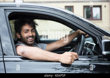 Portrait of a happy Indian man smiling in his new car. Stock Photo
