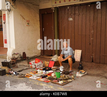 Melaka, Malaysia - Feb 8, 2014. A man selling antique on street in Melaka, Malaysia. Melaka (Malacca) is the third smallest Malaysian state after Perl Stock Photo