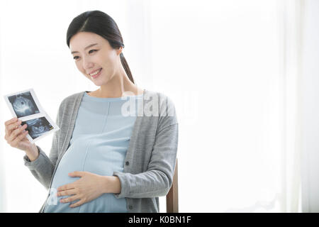 Smiling pregnant woman with sonogram Stock Photo