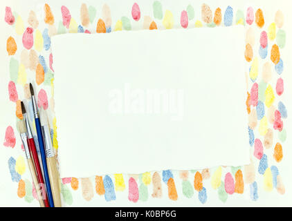 decorative chaotic colorful blobs texture and various paintbrushes with empty paper sheet Stock Photo