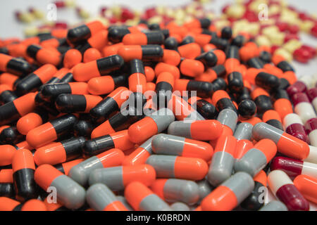 Orange, black, grey, white, red, pale yellow, capsule pills Stock Photo