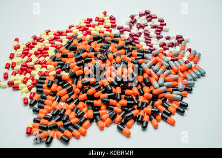 Orange, black, grey, white, red, pale yellow, capsule pills on white background Stock Photo