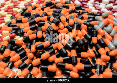 Orange, black, grey, white, red, pale yellow, capsule pills Stock Photo