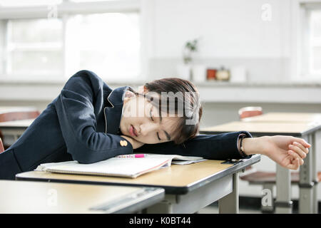 Portrait of school girl tired sleeping in her classroom Stock Photo