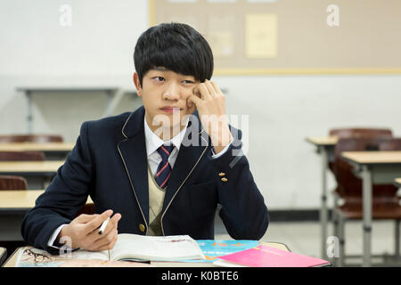 Portrait of bored schoolboy in classroom Stock Photo - Alamy