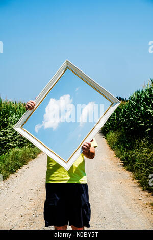 Concept of a man holding picture of the clouds in its hands. Stock Photo