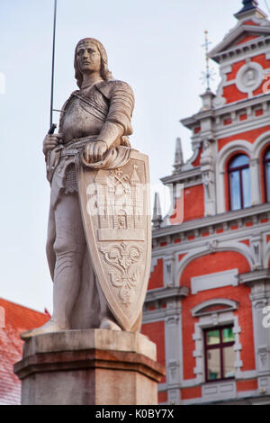 Statue of patron saint Roland standing in Riga old town, Latvia. Behind is the famous Blackheads building. Stock Photo