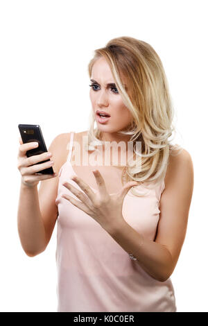 Young beautiful girl with cellphone in hands isolated on white background. Model shows discontent in communication Stock Photo