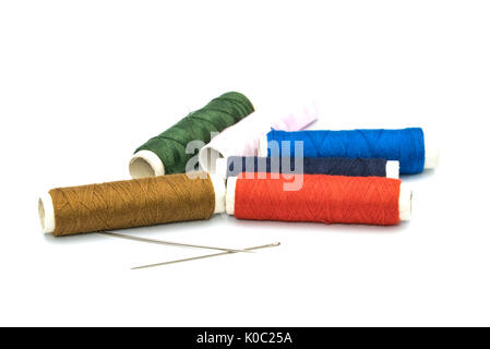 Two needles and six colorful core threads on white background Stock Photo