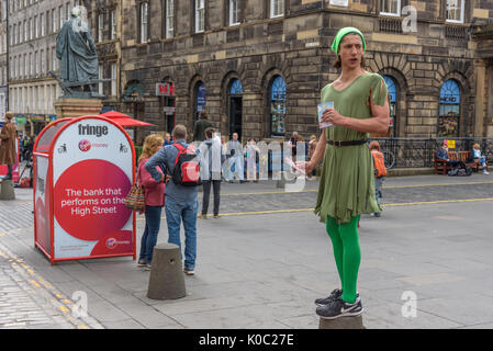 EDINBURGH, UNITED KINGDOM - AUGUST 16, 2017 - A boy advertises a theatrical performance along the Royal Mile of Edinburgh during the 70th anniversary  Stock Photo