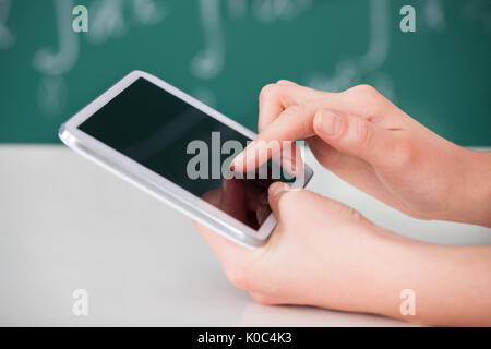 Cropped image of young woman using digital tablet in classroom Stock Photo