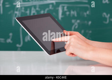 Cropped image of young woman using digital tablet in classroom Stock Photo