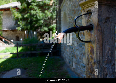 Old rustic water pipe with running drinking water Stock Photo