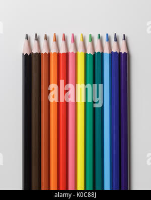 Line of 12 colour pencils on grey background. Top view Stock Photo
