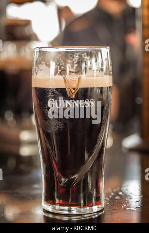 DUBLIN, IRELAND - AUGUST 14: Close up of a glass of Guinness stout beer on a bar counter in Dublin, Ireland