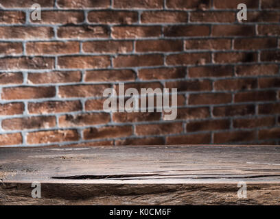 Old wooden empty table and brick wall in the background. Stock Photo