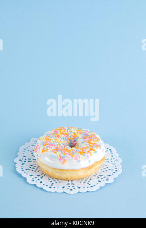 a multicolor donuts presented on a doily paper and a pop colorful background. Stock Photo