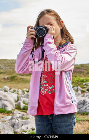 Young girl amateur photographer taking a photo Stock Photo