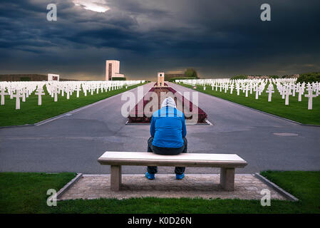 Man sitting on a bench and thinking about all the soldiers that are honored through this American memorial cemetery, located in Luxembourg. Stock Photo