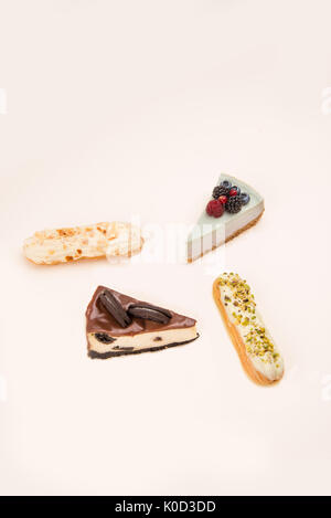 Four different delicious desserts, cakes and eclairs, isolated over white Stock Photo