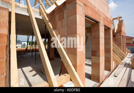 new residential house in construction with bricks and wooden planks Stock Photo