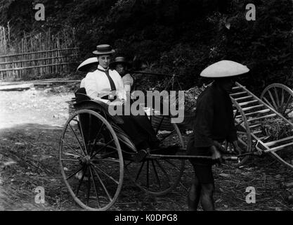 AJAXNETPHOTO. 1900-1910 (APPROX). JAPAN. - OFF WE GO - A LADY BEING TRANSPORTED IN A RICKSHAW.  PHOTOGRAPHER:UNKNOWN © DIGITAL IMAGE COPYRIGHT AJAX VINTAGE PICTURE LIBRARY SOURCE: AJAX VINTAGE PICTURE LIBRARY COLLECTION REF:171308 105 Stock Photo