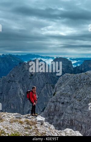 Pizzon, Monti del Sole, Dolomites, Veneto, Italy. Mountaineer on the summit of Pizzon. In the background the Monti del Sole Stock Photo