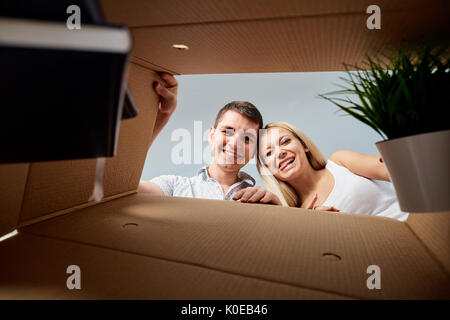 A young couple unpacks boxes. Stock Photo