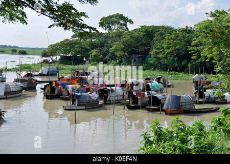 DHAKA, BANGLADESH – AUGUST 19, 2017: A bunch of narrow boats floating on water belonging to gypsies moored at Nawabganj in Dhaka, Bangladesh. The Bede Stock Photo