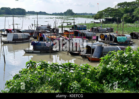 DHAKA, BANGLADESH – AUGUST 19, 2017: A bunch of narrow boats floating on water belonging to gypsies moored at Nawabganj in Dhaka, Bangladesh. The Bede Stock Photo