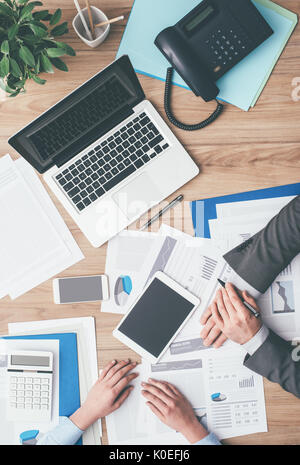 Business team working at office desk and analyzing financial reports, finance and accounting concept, top view Stock Photo