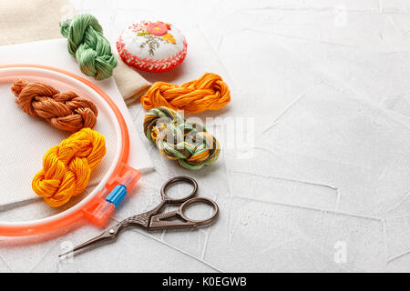 Set for embroidery, embroidery hoop, linen fabric, thread, scissors, embroidered needle bed Stock Photo