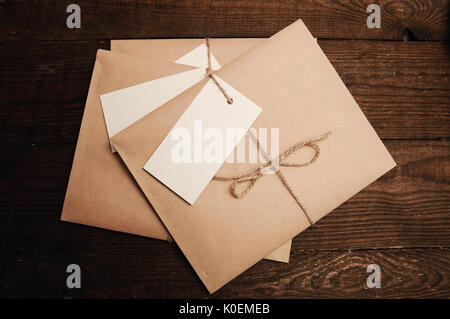 Note from a paper on a cord of an envelope from kraft paper on a wooden table Stock Photo