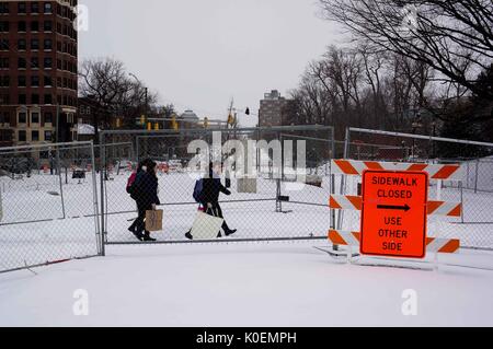 College students cross Charles street, which is covered in snow and has construction signs and fences around it, to get to the Homewood campus of the Johns Hopkins University in Baltimore, Maryland, 2014. Courtesy Eric Chen. Stock Photo