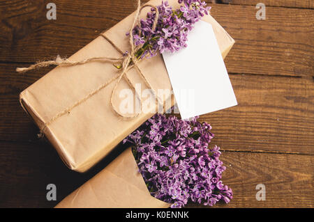 Bouquet of lilacs on a wooden table with a gift box of kraft paper Stock Photo