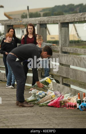 Shoreham-by-Sea, Sussex, UK, 22nd August 2017. On the 2nd anniversary of the disaster at Shoreham Airshow, families and others gathered to remember the eleven men who died. The disaster happened when a Hawker Hunter jet crashed into a busy road junction during the airshow, the families held a two minute silence on a wooden bridge across the river Adur close the site of the crash. Roland Ravenhill/Alamy Live News Stock Photo