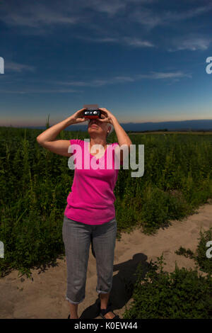 Arnold, United States. 21st Aug, 2017.  Susan Newell, 68, watches the total eclipse of the sun, just before totality, from the Nebraska Sandhills. MR Credit: Jim West/Alamy Live News Stock Photo