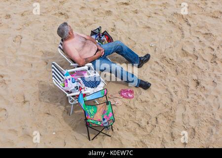 Bournemouth, Dorset, UK. 22nd Aug, 2017. UK weather: after a foggy start, mixed weather with sunshine and showers at Bournemouth beaches - the showers don't deter visitors from heading to the seaside. Credit: Carolyn Jenkins/Alamy Live News Stock Photo
