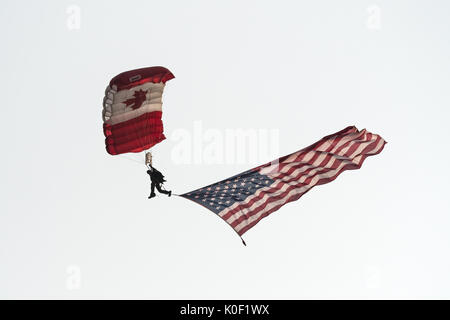 August 11, 2017 - Abbotsford, British Columbia, Canada - A member of the Canadian Armed Forces SkyHawk parachute team, displaying one of the team's signature Canadian flag parachutes and a large American flag, during the opening aerial display of the Abbotsford International Airshow, August 11, 2017. (Credit Image: © Bayne Stanley via ZUMA Wire) Stock Photo