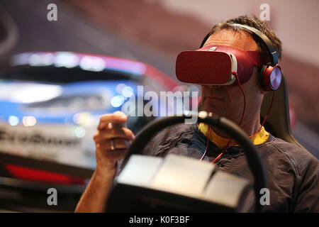 Cologne, Germany. 23rd Aug, 2017. Visitors to the Gamescom playing a computer game with VR (Virtual Realitiy) headset in Cologne, Germany, 23 August 2017. The computer games fair Gamescom takes place between 22 and 26 August 2017. Photo: Oliver Berg/dpa/Alamy Live News Stock Photo