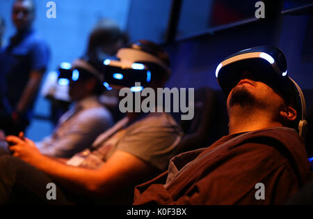 Cologne, Germany. 23rd Aug, 2017. Visitors to the Gamescom playing a computer game with VR (Virtual Realitiy) headsets in Cologne, Germany, 23 August 2017. The computer games fair Gamescom takes place between 22 and 26 August 2017. Photo: Oliver Berg/dpa/Alamy Live News Stock Photo