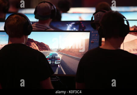 Cologne, Germany. 23rd Aug, 2017. Visitors to the Gamescom playing a computer game in Cologne, Germany, 23 August 2017. The computer games fair Gamescom takes place between 22 and 26 August 2017. Photo: Oliver Berg/dpa/Alamy Live News Stock Photo
