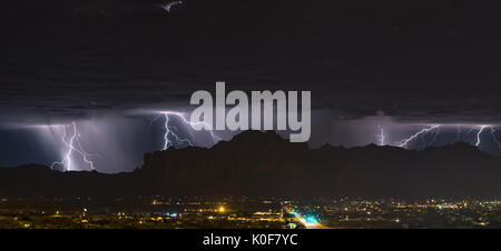 Frequent lightning flashes behind the silhouette of the Superstition Mountains as a late night thunderstorm moves through Mesa, Arizona Stock Photo