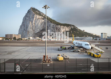 An aircraft on the tarmac at Gibraltar International Airport with Gibraltar Rock seen in the background. Stock Photo