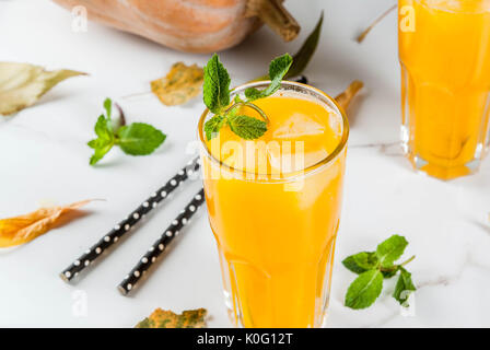 Fall and winter cold cocktails. Spicy pumpkin mojito with fresh mint, on white marble table. copy space Stock Photo