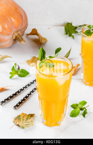 Fall and winter cold cocktails. Spicy pumpkin mojito with fresh mint, on white marble table. copy space Stock Photo